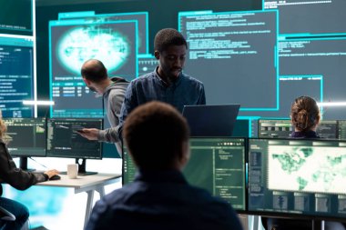 Yüksek teknoloji ofisindeki bilgisayar ağında çalışan hükümet hackerları veri güvenliği ve siber operasyonlara odaklanıyorlar. Siber suçlar, veri koruması ve güvenli ortamda tehdit tespiti.