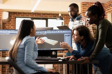 Erkek ve kadın yaratıcı profesyoneller bilgisayarda 3 boyutlu bir sahneyi geliştirmek için beyin fırtınası yapıyorlar. Uzman CAD yazılımı kullanarak ağ detaylarını optimize etmek için birlikte çalışan çok ırklı dijital sanatçılar.