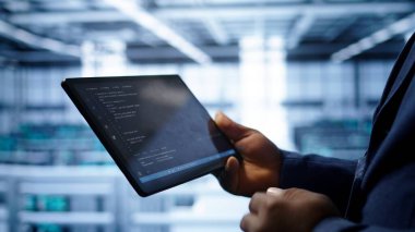 Programcı sunucu odası donanımlarını izliyor, kontrol ediyor, gerekli düzeltmelerin tabletine veri giriyor. Bilgi işlem merkezi depolama donanımı üzerinde çalışan bilişim uzmanı. Kamera B, kapat.