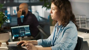 Bilgisayar masasındaki büro görevlisi belgeleri okuyor, görevleri çözüyor. Personel üyesi evrak belgelerindeki verileri analiz ediyor, istatistiksel bilgileri yorumluyor, kamera A