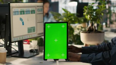 Çalışanların önündeki yeşil ekran tabletinin projedeki ilerlemesini kontrol et. Ofis memurlarının yanında Chroma anahtar cihazı PC ekranında veri istatistikleri okuyor, kamera A