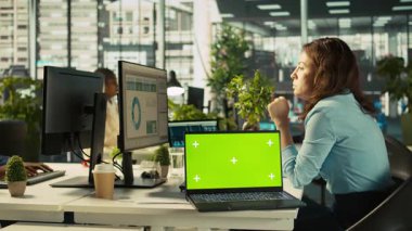 Ofis masasındaki yeşil ekran dizüstü bilgisayarda çalışan kurgu belgelerinin yanında. Veri tablolarını analiz eden, istatistiksel bilgileri yorumlayan, B kamerasının yanındaki defter.