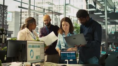 Ofisteki iş arkadaşları beyin fırtınası yapıyor, finansal tabloları inceliyor, iş performans ölçümlerini inceliyor. İş yerinde çalışan iş arkadaşları sohbet ediyor, veri eğilimlerini inceliyor, kamera B