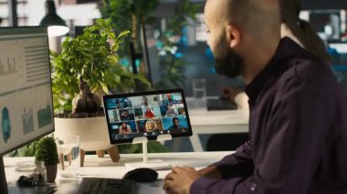 Ofiste çalışan bir işçi internet video görüşmesi sırasında iş arkadaşlarıyla konuşuyor. İşyerindeki çalışanlar uzaktan telekonferans toplantısında iş ortaklarıyla tartışıyor, ölçümleri analiz ediyor, kamera A