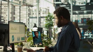 Video konferansında çalışanlarla sohbet etmek, performans ve şirket büyümesi için hedefler belirlemek. İşçilerle telekonferans toplantısının yöneticisi tablet, kamera B kullanıyor.