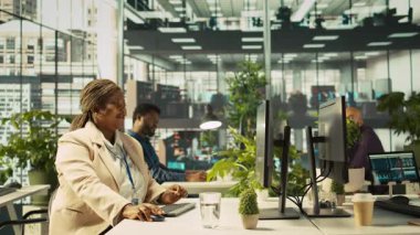 Finansal grafikleri incelerken neşeli iş arkadaşları coşkulu ofiste eğleniyorlar. Neşeli meslektaşlar çalışırken şakalarını paylaşıyor, veri eğilimlerine ve stratejik görüşlere bakıyor, kamera B