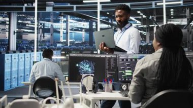 Happy Veri Merkezi Yöneticisi dizüstü bilgisayarda düğüm ağacı programlama kullanır, iş arkadaşıyla beşlik çakar. Gülümseyen sunucu çiftliği çalışanı iş arkadaşını selamlıyor, veri analiz grafiğini inceliyor, kamera A