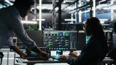 Sunucu merkezi ekip lideri ve çalışanı sistem sağlığını optimize etmek için düğüm ağacı yazılımı kullanıyor. Yapay zeka görsellemesi kullanarak altyapı sorunlarını analiz eden bilişim uzmanını denetleyen veri merkezi yöneticisi, kamera B
