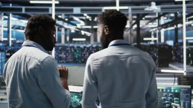 Sunucu merkezi mühendislik ekibi yapay zeka veri analizi grafiklerini yorumluyor. Öngörü sistemi ölçümleri gösteren yapay zeka programı kullanan takım çalışması veri merkezi meslektaşları, kamera A