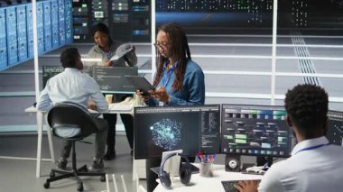 Sunucu merkezindeki kadın, sistem sağlığını optimize etmek için tablet cihazında yapay zeka görselleme öngörüleri kullanıyor. Veri merkezi bilgisayar bilimcisi düğüm ağacı araçları kullanarak altyapı sorunlarını analiz ediyor, kamera A