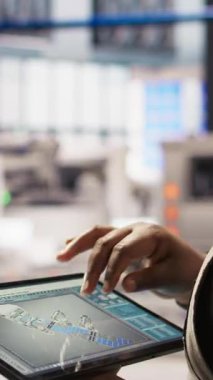 Akıllı fabrika düzeni tasarlamak için CAD uygulaması kullanan teknisyenlerin dikey görüntüsü. Otomatik üretim sistemlerini simule etmek ve optimize etmek için aygıt üzerinde simülasyon uygulaması kullanan uzman