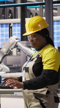 Sektördeki gülümseyen kadının dikey video görüntüsü 4.0 güneş paneli yenilenebilir enerji üreten bitki. Fotovoltaik mühendisi akıllı fabrika verileri analiz ediyor, sistem ölçümlerini gözden geçiriyor, kamera A