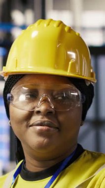 Endüstriyel fabrikadaki gülümseyen teknisyenlerin dikey video portresi güneş enerjisi kurulum sürecini denetliyor. Otomatik robotik kalibre edilen yenilenebilir enerji üretim tesisinde mutlu bir işçi.