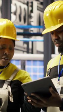 Sektör 4.0 tesisinde arızaları tespit etmek için birlikte çalışan dikey video mühendisliği ekibi. Takım çalışması fabrikasındaki iş arkadaşları montaj hatları ve kamera B 'deki tamir görevlerini koordine ediyorlar.