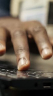 Otomatik sistemleri test etmek ve üretim ölçümlerini izlemek için dizüstü bilgisayar kullanan akıllı fabrika işçisinin dikey videosu. Sektör 4.0 tesis uzmanı, arızaları tespit etmek ve düzeltmek için makineleri denetliyor