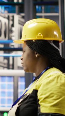 Endüstriyel fabrikadaki dikey video teknisyeni PC yazılımı kullanarak üretim ekipmanlarını izliyor ve arızaları teşhis ediyor. Fabrika çalışanı koordinatları bilgisayar kullanarak montaj hatlarındaki görevleri onarıyor