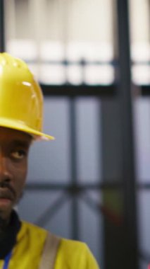 Akıllı bir fabrikada mühendis tarafından yapılan ve imalat sırasında kalite kontrolü sağlayan dikey video yöneticisi. Ekip lideri otomatik taşıma sistemlerini ve kamerayı izleyen çalışanları denetliyor.