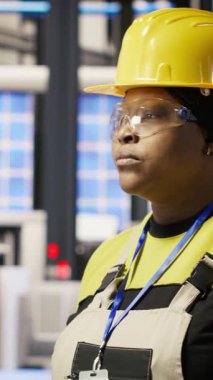 Sektördeki gülümseyen kadının dikey video görüntüsü 4.0 güneş paneli yenilenebilir enerji üreten bitki. Fotovoltaik mühendisi akıllı fabrika verileri analiz ediyor, sistem ölçümlerini gözden geçiriyor, kamera B