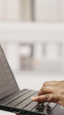 Sürdürülebilir sanayi santralindeki dikey video teknisyeni dizüstü bilgisayar kullanarak üretim ekipmanlarını izliyor ve arızaları teşhis ediyor. Fabrika işçisi, güneş modülü montaj hattındaki tamir görevlerini koordine ediyor