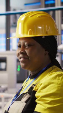 Sistem performans ölçümlerine bakan akıllı fotovoltaik fabrikasındaki dikey video mühendisi Happy. Güneş panellerindeki gülümseyen işçi IoT sensörleri ve kamera A aracılığıyla enerji üretimini takip ediyor.