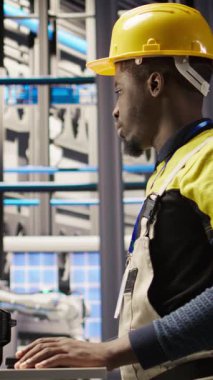 Dikey video güneş panelleri fabrika mühendisi PC 'yi sistemleri denetlemek için kullanır, makinelerin en uygun verimlilikte çalışmasını sağlar. Fotovoltaik fabrika işçisi devamlı devam etmek için bilgisayar yazılımı kullanıyor