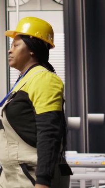 Akıllı fabrikadaki dikey video mühendisi robot montaj hatlarını denetliyor, imalat sürecinde kalite kontrolü sağlıyor. İşçi otomatik taşıma sistemlerini izliyor, bakım yapıyor, kamera A