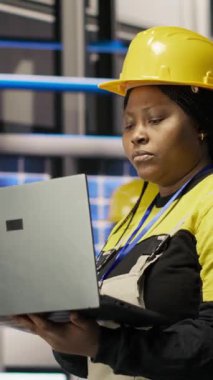 Dikey video mühendisi akıllı fabrikada yürüyor, IoT sensör verilerini analiz etmek ve vites verimliliğini rafine etmek için dizüstü bilgisayar kullanıyor. Endüstri 4.0 bitkisel uzmanlık sistemi sistem tanılama çalışmalarını durdurma süresi ve kamera