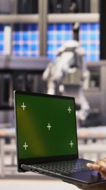 Yenilenebilir enerji endüstrisi 4.0 santralinde yeşil ekran dizüstü bilgisayar kullanan dikey video uzmanı. Fotovoltaik teknisyeni. Krom anahtar not defteri kullanarak akıllı fabrika test ekipmanları.