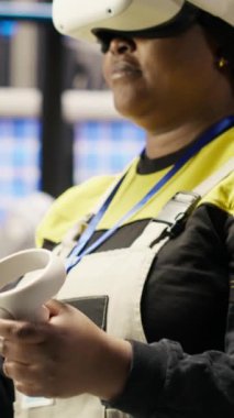 Sektör 4.0 'da çalışan dikey video mühendisi ekipmanları kontrol etmek için sanal gerçeklik teknolojisini kullanıyor. Otomasyon sistemlerini yönetmek ve geliştirmek için VR kulaklık kullanan akıllı bir fabrika çalışanı, kamera B