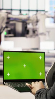 Yenilenebilir enerji endüstrisi 4.0 santralinde yeşil ekran dizüstü bilgisayar kullanan dikey video uzmanı. Fotovoltaik teknisyeni. Krom anahtar not defteri kullanarak akıllı fabrika test ekipmanları.