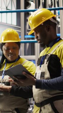 Dikey video güneş panelleri fabrika mühendisliği ekibi vites arızalarını tahmin etmek için dizüstü bilgisayardaki performans verilerini analiz eder. Takım çalışması fotovoltaik, bakım prosedürlerini takip eden meslektaşları, kamera A