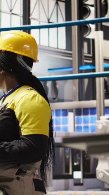 Akıllı fabrikada gülen bir mühendis tablet kullanarak, IoT sensör verilerini analiz ederek öngörü onarımı yapıyor. Fotovoltaik 'in işlevsel güvenilirliğini yöneten endüstriyel fabrika işçisi