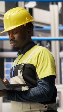 Endüstriyel santraldeki dikey video teknisyeni güneş enerjisi kurulum sürecini denetliyor, sorun çıkarma hataları. Yenilenebilir enerji üretim tesisi çalışanı otomatik robotik silahları kalibre ediyor