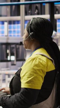 Dikey video Otomatik üretim fabrikası uzmanı canlı üretim verilerini analiz ediyor, mikrofon kullanarak mühendislere robotik silahlar, taşıma bantları ve fotovoltaik kayışlar hakkında bilgi aktarıyor.