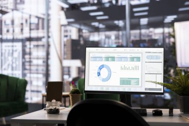 Modern ofis masası mali verileri monitörde gösterir. Ayrıntılı analitik ve grafikler, veri yönetimi ve analiz araçları tarafından desteklenen iş stratejisini ve başarıyı vurguluyor.