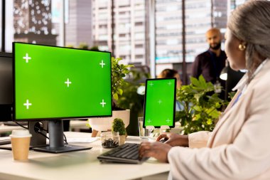 İzole ekranın yanında iş analizleri yapan şirket çalışanları online raporlar ve verilerle sıkı çalışıyorlar. Modern çalışma alanındaki idari ve idari görevlerin çözümü.