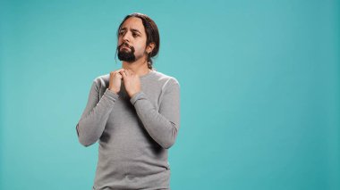 Stüdyonun arka planında izole edilmiş kafa karıştırıcı bilgilerle kafası karışmış bir adamın portresi. Kafasını kaşıyan kişi, etrafa şaşkın bir yüz ifadesiyle bakıyor, kamera B