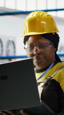 Dikey video kadın, 4.0 güneş paneli fabrikasında dizüstü bilgisayar kullanarak rutin teftişler yapıyor. Fotovoltaik mühendisliği akıllı fabrika test ekipmanları ve sistem ölçümleri defter kullanarak gözden geçirme