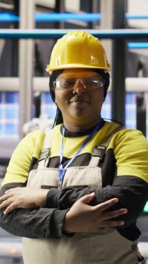 Endüstriyel fabrikadaki gülen teknisyenlerin ekipman hatalarını teşhis etmeye çalışan dikey video portresi. Jolly imalat fabrikası montaj hatlarında profesyonel onarım görevleri, kamera B