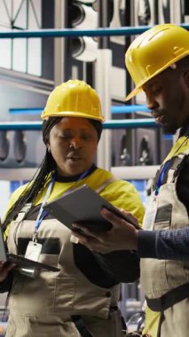 Sektör 4.0 tesisinde arızaları tespit etmek için birlikte çalışan dikey video mühendisliği ekibi. Takım çalışması fabrikasındaki iş arkadaşları montaj hatları ve kamera A 'daki tamir görevlerini koordine ediyorlar.