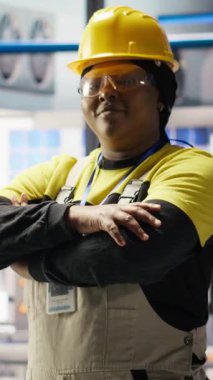 Yüksek teknoloji makinelerini ayarlayan ve sensör verilerini analiz eden çok zeki bir fabrika mühendisinin dikey video portresi. Mutlu endüstriyel fabrika işçisi sorun çıkaran montaj ekipmanı, kamera B