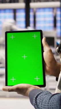 Dikey video Photovoltaics fabrika çalışanı bakım prosedürlerini takip etmek için kroma anahtar defteri kullanıyor. Güneş panelleri fabrika mühendisi, izole ekran dizüstü bilgisayar ve kamera ile performans verilerini analiz eder.