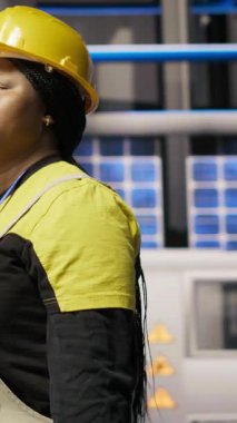 Dikey video tamircisi alet çantasını tutuyor akıllı fabrikada yürüyor, bakım yapmaya hazırlanıyor. Tamirci sektör 4.0 tesisini teftiş ediyor, tamir için ekipman hasarı arıyor, bakım yapıyor.