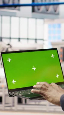 Dikey video akıllı fabrika mekaniği otomatik sistemleri izole ekran dizüstü bilgisayar kullanarak, bakım yaparak test ediyor. Endüstri 4.0 tesis işçisi kimlik belirlemek için model not defteri kullanarak ekipmanları denetliyor