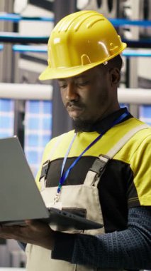 Dikey video akıllı fabrika uzmanı, otomatik sistemleri test ediyor, üretim performansını izliyor. Endüstri 4.0 fabrika teknisyeni, B kamerasını tespit etmek ve optimize etmek için makine denetliyor.