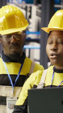 Dikey video mühendisliği ekibi, güneş paneli üretim ekipmanlarını denetliyor. Otomatik sanayi 4.0 fabrikasındaki fotovoltaik montaj sistemlerini koruyan takım arkadaşları