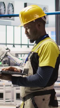 Akıllı fabrikadaki dikey video mühendisi dizüstü bilgisayar yazılımı kullanarak IoT sensör verilerini analiz ediyor. Fotovoltaik sistemlerin işlevsel güvenilirliğini yöneten sanayi 4.0 fabrika işçisi