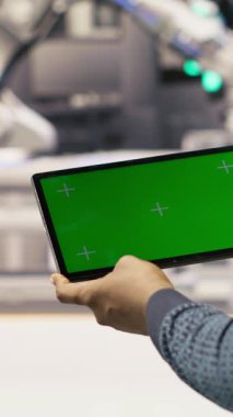 Dikey video Photovoltaics fabrika çalışanı bakım prosedürlerini takip etmek için kroma anahtar defteri kullanıyor. Güneş panelleri fabrika mühendisi performans verilerini izole ekran bilgisayarı ve kamera B ile analiz eder.