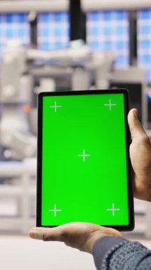 Dikey video akıllı fabrika uzmanı otomatik iş akışlarını uygulamak için yeşil ekran tableti kullanır. Endüstri 4.0 fabrika teknisyeni sensörleri krom anahtar cihazı ve kamera kullanarak üretime entegre ediyor.