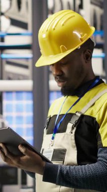Montaj hatlarını yükseltmeden önce IoT sensörlerinin verilerini analiz etmek için tablet kullanan dikey video akıllı fabrika tamircisi. Endüstri 4.0 fabrika personeli hata ve kameraları azaltmak için sistem kontrolü yapıyor
